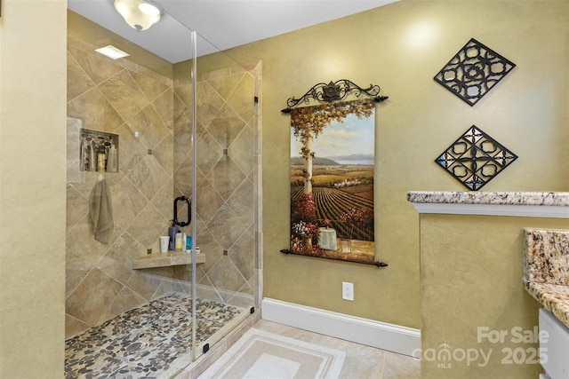 full bathroom with baseboards, vanity, and a shower stall