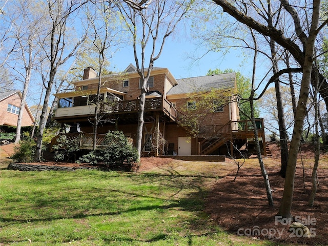 back of property featuring a yard, a chimney, stairs, and a wooden deck
