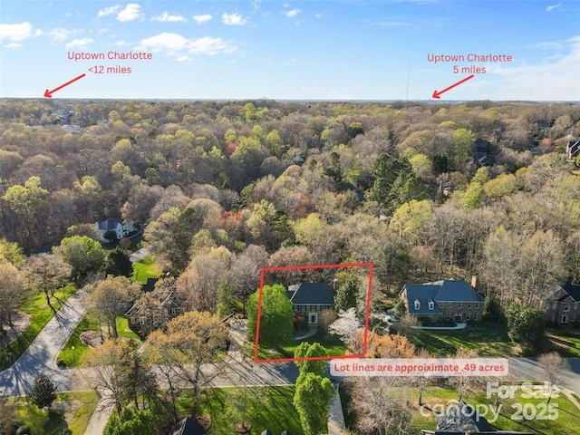 drone / aerial view with a wooded view