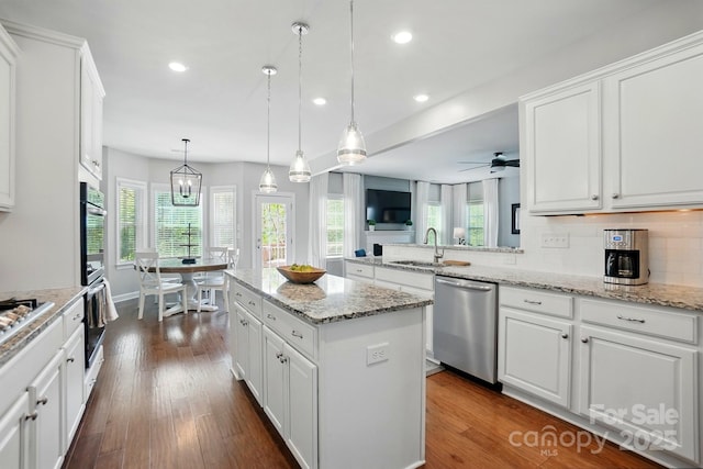 5140 Oak Grove Pl, Waxhaw, NC 28173 - kitchen with white cabinets, a center island, recessed lighting, stainless steel appliances, and decorative backsplash