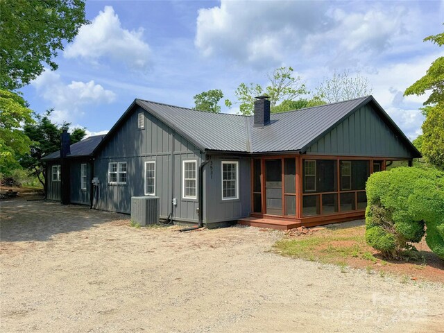 3531 Big Level Rd, Mill Spring, NC 28756 - rear view of house featuring board and batten siding, central AC unit, a chimney, and metal roof