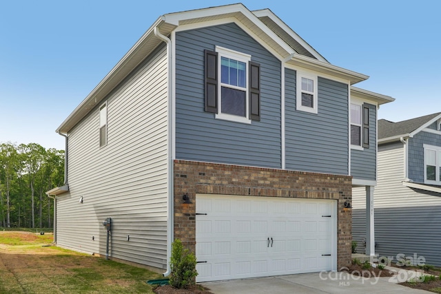 1305 31st St NE, Conover, NC 28613 - view of property exterior featuring an attached garage, concrete driveway, and brick siding