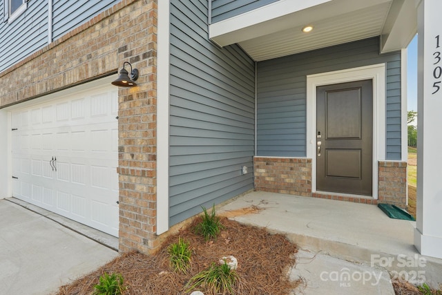 1305 31st St NE, Conover, NC 28613 - doorway to property featuring brick siding and a garage