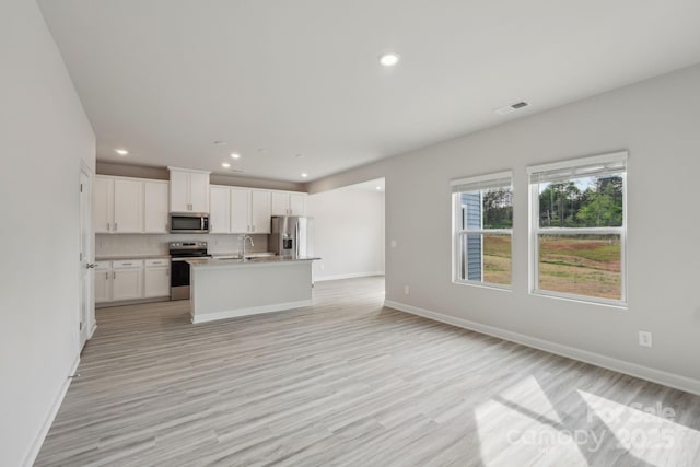 1305 31st St NE, Conover, NC 28613 - kitchen with light wood finished floors, visible vents, open floor plan, and appliances with stainless steel finishes