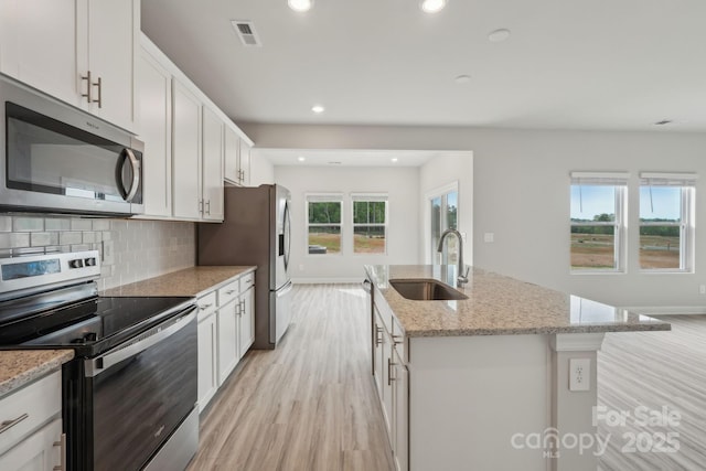 1305 31st St NE, Conover, NC 28613 - kitchen featuring appliances with stainless steel finishes, visible vents, a sink, light wood-style floors, and an island with sink