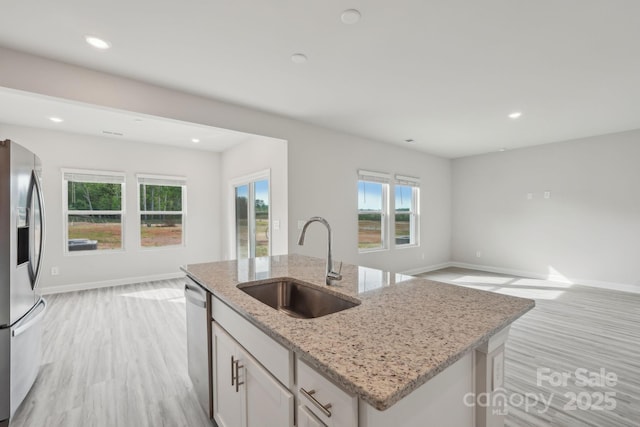 1305 31st St NE, Conover, NC 28613 - kitchen with baseboards, a sink, open floor plan, stainless steel appliances, and light wood-type flooring