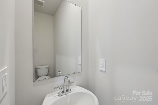 1305 31st St NE, Conover, NC 28613 - bathroom with toilet, visible vents, and a sink