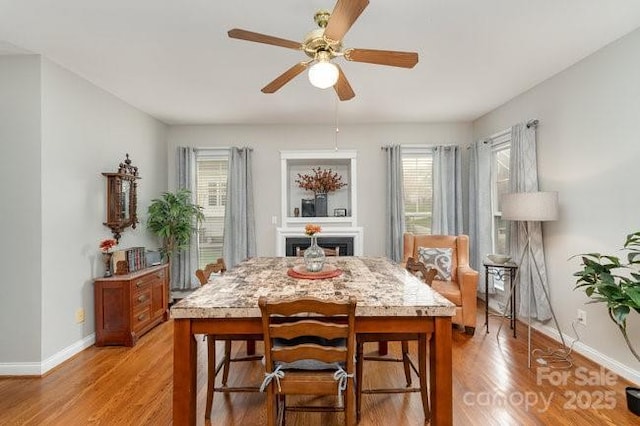 10802 Tradition View Dr, Charlotte, NC 28269 - dining space with baseboards, a fireplace, light wood-style flooring, and a ceiling fan