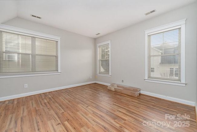 10802 Tradition View Dr, Charlotte, NC 28269 - unfurnished room with visible vents, baseboards, lofted ceiling, and wood finished floors