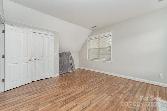 10802 Tradition View Dr, Charlotte, NC 28269 - additional living space with baseboards, vaulted ceiling, and light wood-style floors