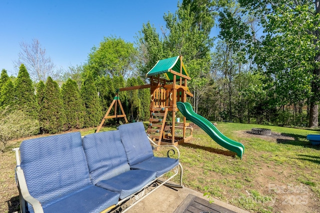 view of playground featuring an outdoor fire pit and a lawn
