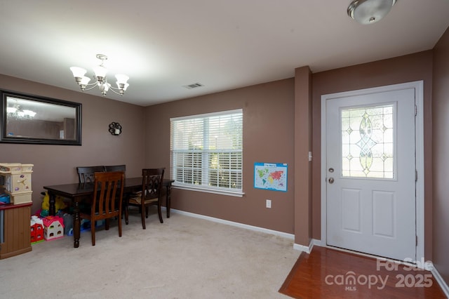 dining room featuring visible vents, baseboards, an inviting chandelier, and carpet floors