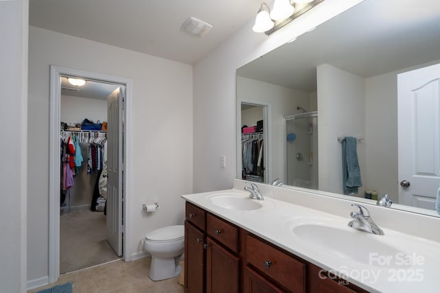 full bathroom with toilet, double vanity, a sink, and a stall shower