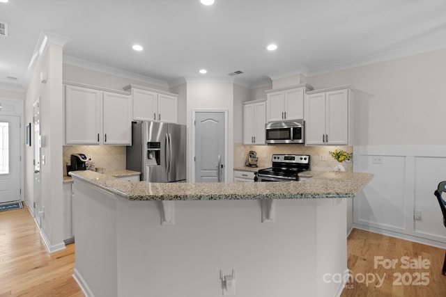 6021 Sweetbay Ln, Indian Land, SC 29707 - kitchen with white cabinetry, light wood-style floors, a kitchen bar, and stainless steel appliances