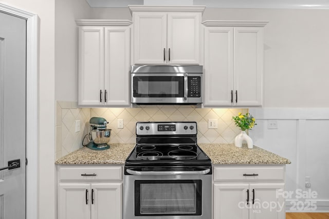 6021 Sweetbay Ln, Indian Land, SC 29707 - kitchen featuring white cabinetry, light stone counters, decorative backsplash, and appliances with stainless steel finishes