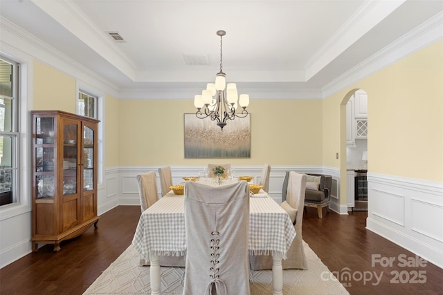 dining room with an inviting chandelier, dark wood-style floors, and a tray ceiling