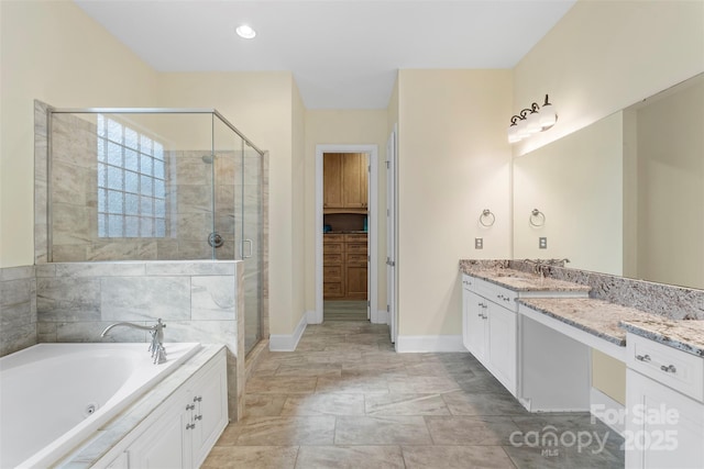 bathroom featuring baseboards, a tub with jets, a stall shower, and vanity
