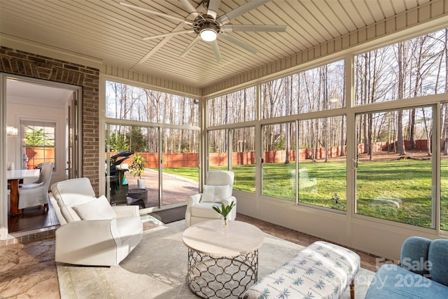 sunroom with a wealth of natural light, outdoor lounge area, and a ceiling fan