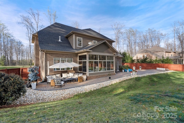 back of house with brick siding, a yard, a patio area, and fence