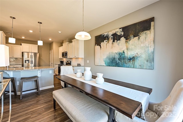 dining area featuring dark wood-type flooring and recessed lighting