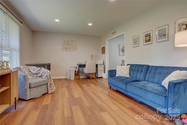 living room featuring light wood finished floors, baseboards, and recessed lighting