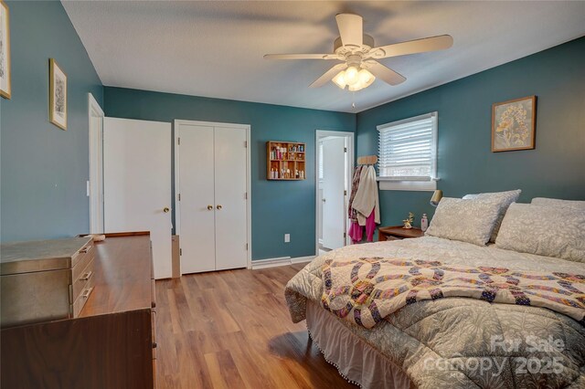 bedroom with baseboards, ceiling fan, and wood finished floors