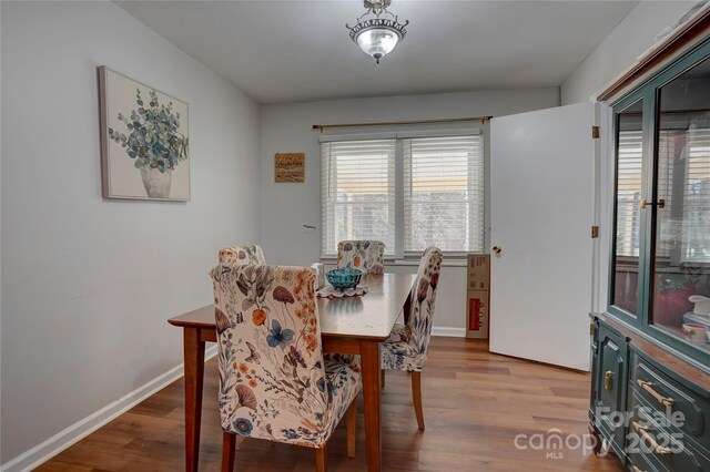dining space featuring baseboards and wood finished floors