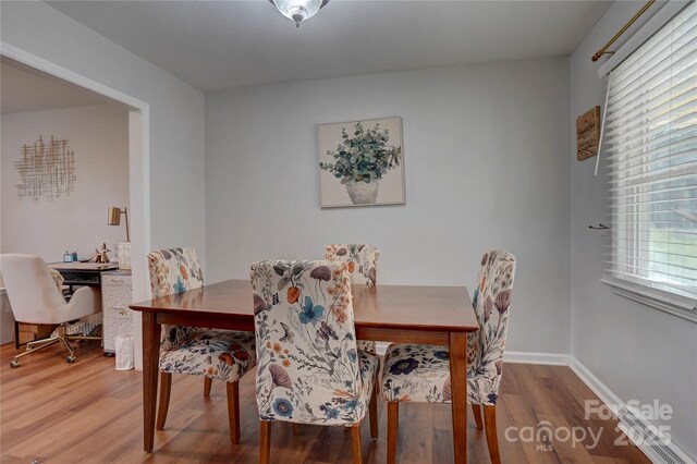 dining space featuring baseboards and wood finished floors