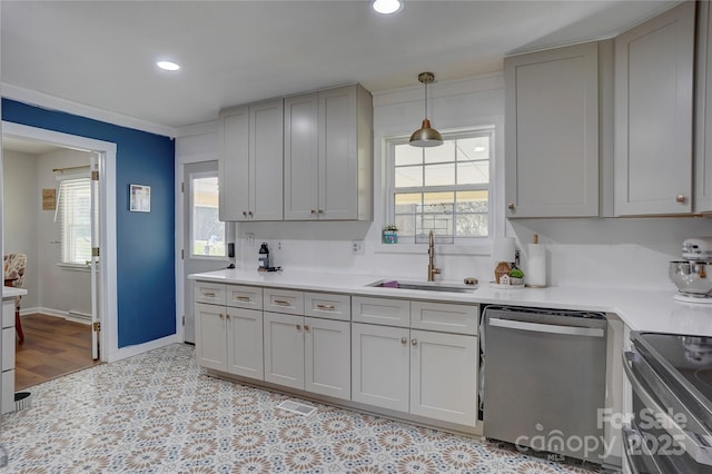 kitchen with light countertops, a sink, stainless steel appliances, baseboards, and recessed lighting