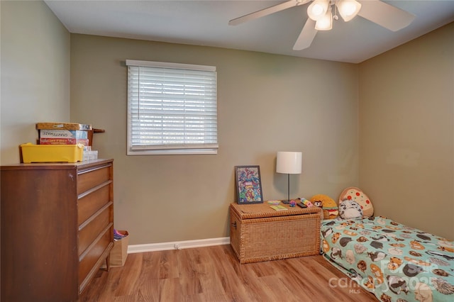 bedroom featuring light wood finished floors, baseboards, and a ceiling fan