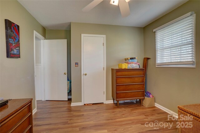 bedroom with baseboards, light wood-style floors, and a ceiling fan