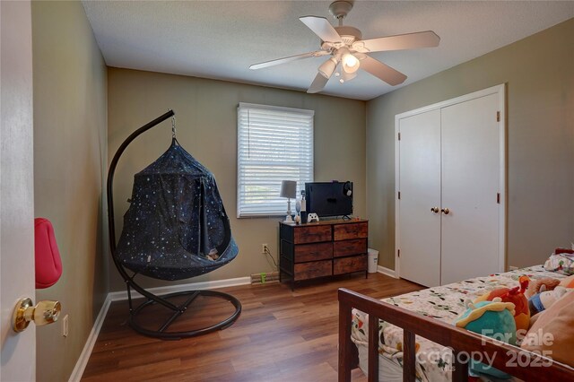 bedroom with a closet, baseboards, ceiling fan, and wood finished floors