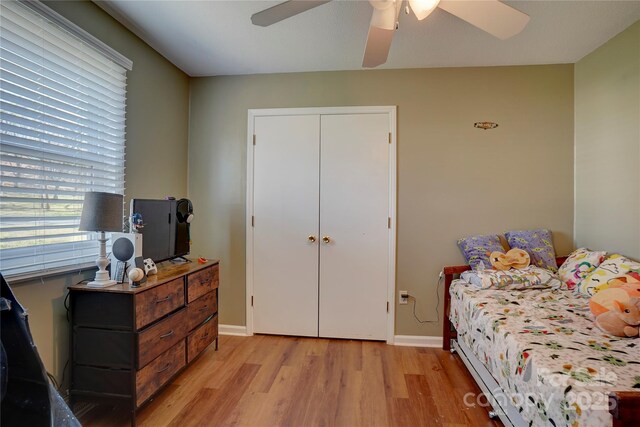 bedroom featuring baseboards, light wood-style flooring, and a ceiling fan