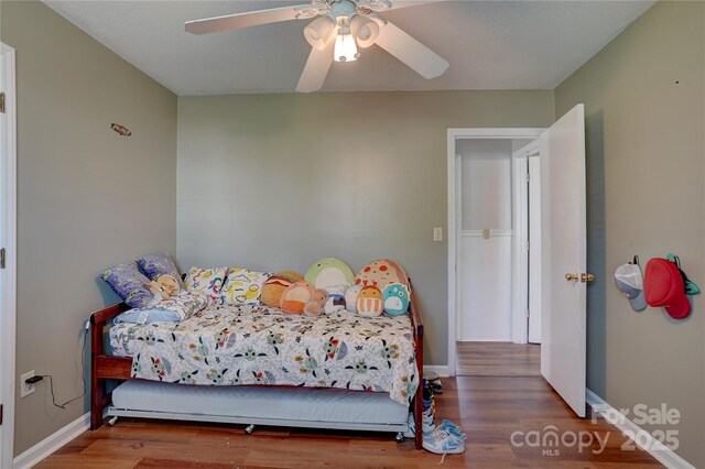bedroom featuring baseboards, ceiling fan, and wood finished floors