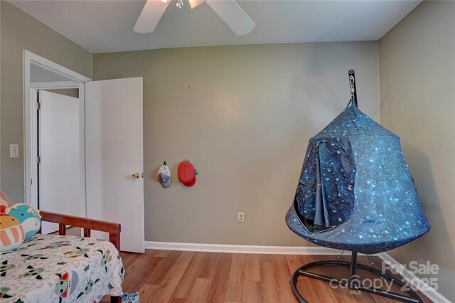 bedroom with baseboards, wood finished floors, and a ceiling fan
