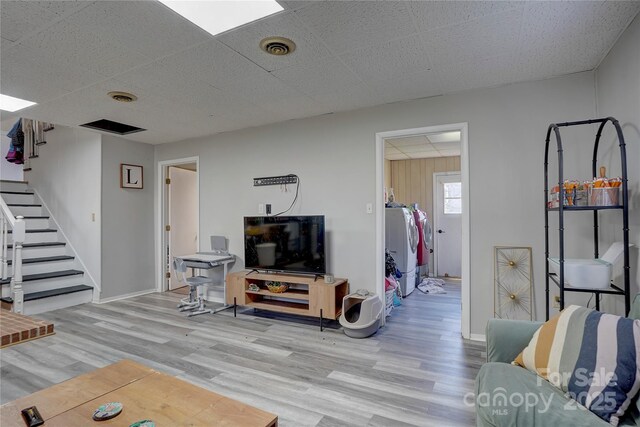 living area with visible vents, stairway, and wood finished floors