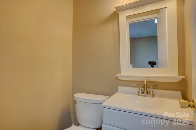 half bathroom with toilet and vanity
