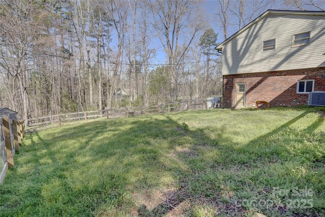 view of yard featuring a fenced backyard and central air condition unit