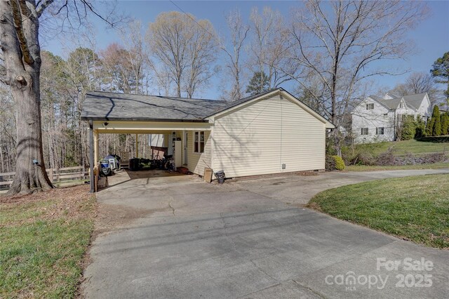 view of home's exterior featuring driveway, a yard, and a carport