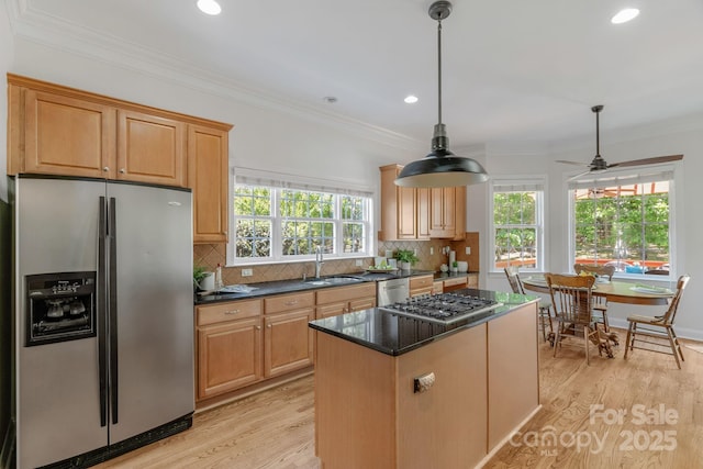 kitchen with recessed lighting, a center island, a sink, light wood finished floors, and stainless steel appliances