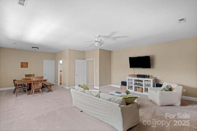 carpeted living room featuring baseboards, a ceiling fan, and visible vents
