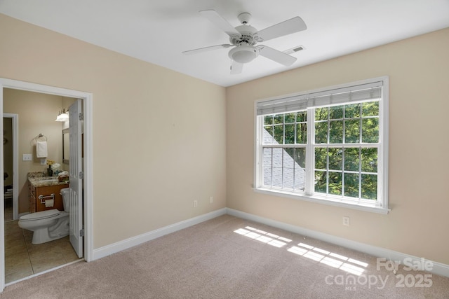 unfurnished bedroom with carpet flooring, baseboards, visible vents, and connected bathroom