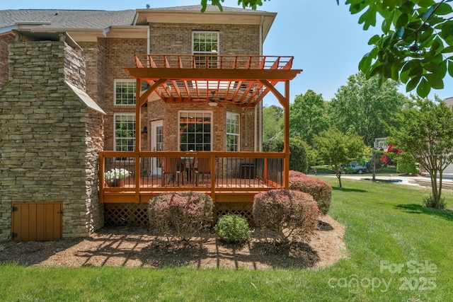 back of house featuring brick siding, ceiling fan, a deck, a balcony, and a yard