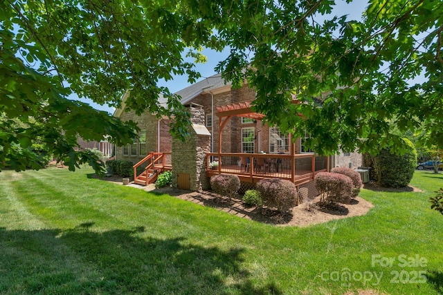 back of house featuring a lawn, a wooden deck, cooling unit, and brick siding