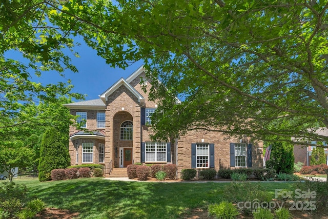 traditional-style home featuring brick siding and a front yard