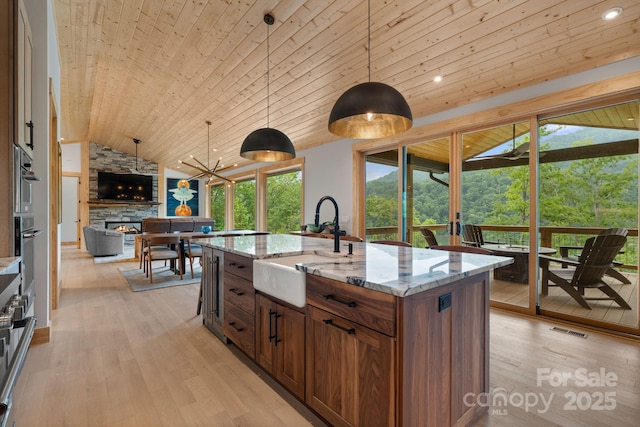 192 Lakeview Trl, Bryson City, NC 28713 - kitchen featuring wooden ceiling, a sink, vaulted ceiling, light wood-type flooring, and a stone fireplace