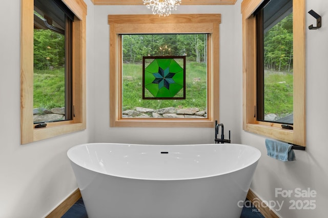 192 Lakeview Trl, Bryson City, NC 28713 - bathroom with baseboards, a freestanding tub, and a chandelier