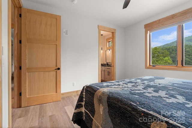 192 Lakeview Trl, Bryson City, NC 28713 - bedroom with wood finished floors, baseboards, ensuite bath, and a ceiling fan