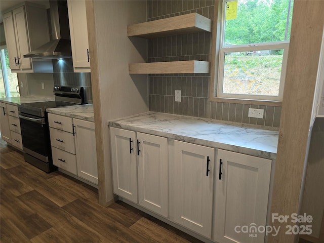 kitchen featuring wall chimney exhaust hood, stainless steel electric range, dark wood-style floors, decorative backsplash, and white cabinets