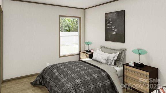 bedroom featuring wood finished floors, crown molding, and baseboards